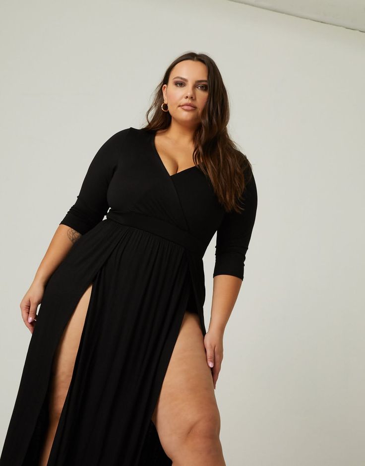 Woman in a black dress with high slits and cleavage in a studio setting