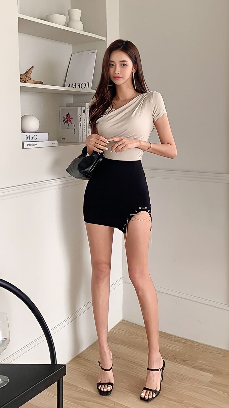 Woman in a beige top and black mini skirt with cutouts and chains