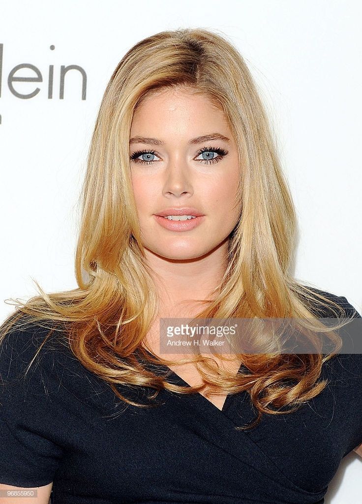 Woman with blonde hair and blue eyes wearing a black top