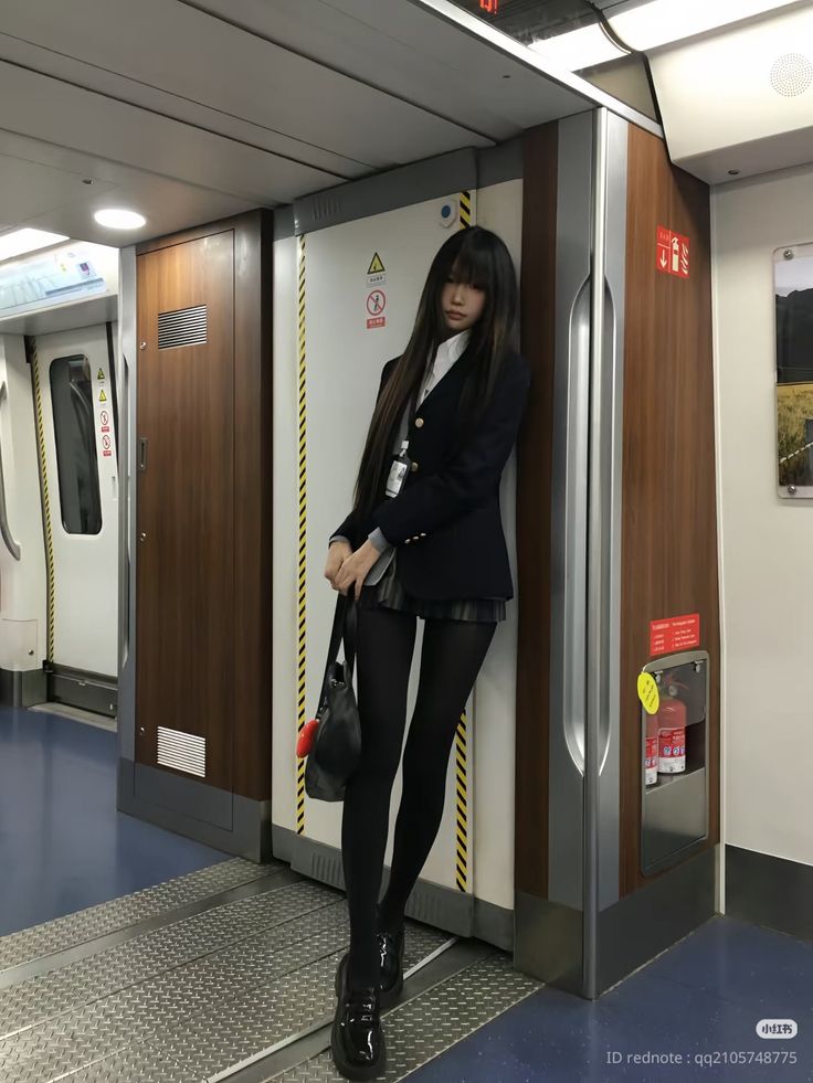Woman in a school uniform and black tights standing in a subway train