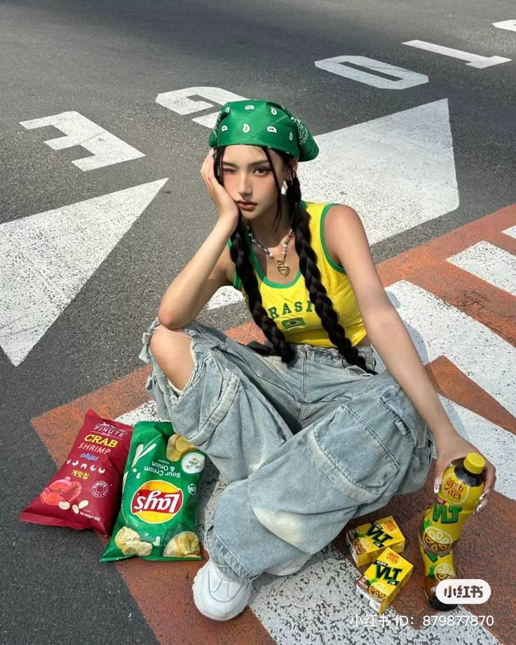 Woman in a green bandana and ripped jeans sitting on a street