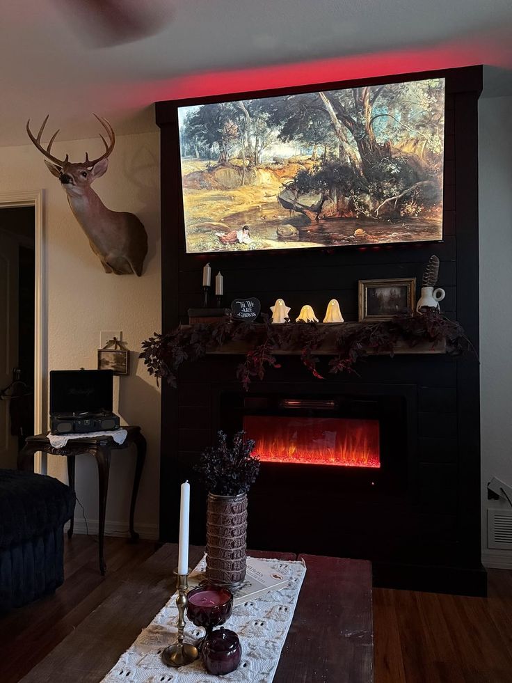 Living room with a fireplace, deer head mount, and Halloween decorations
