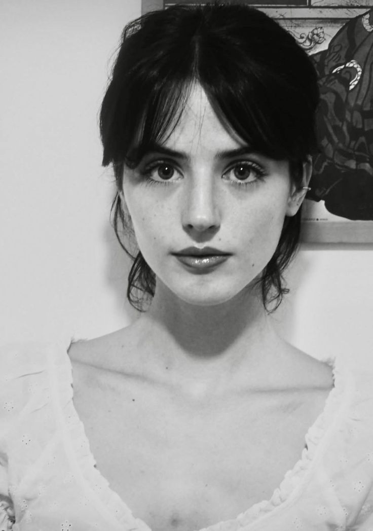 Black and white portrait of a woman with dark hair and a white top