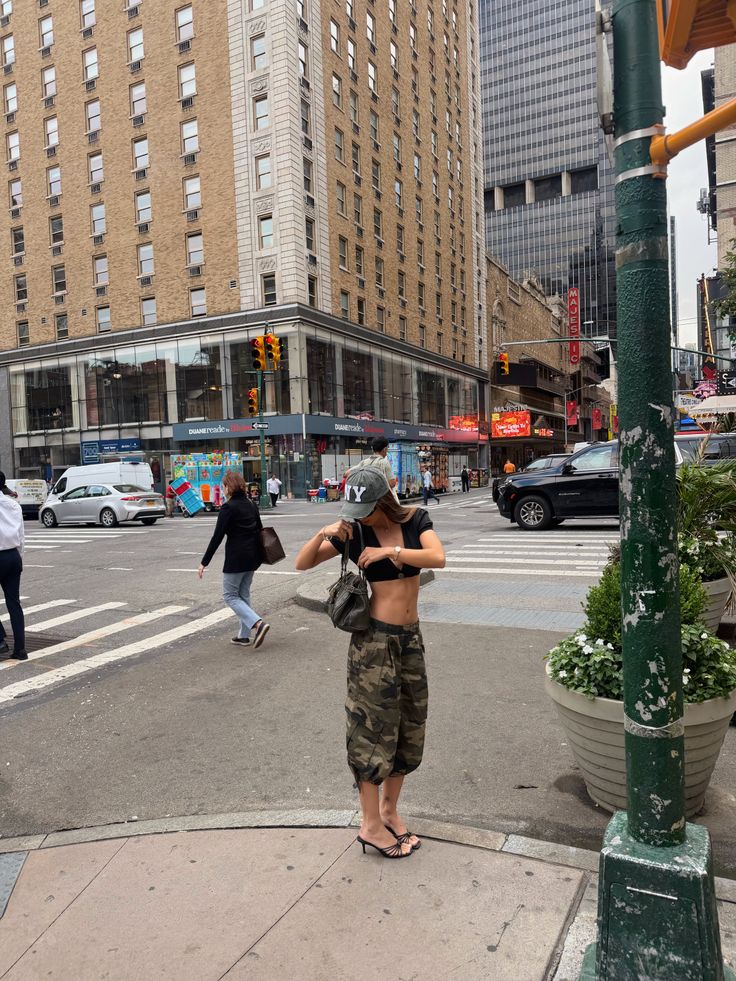 Woman in a crop top and camouflage pants on a city street