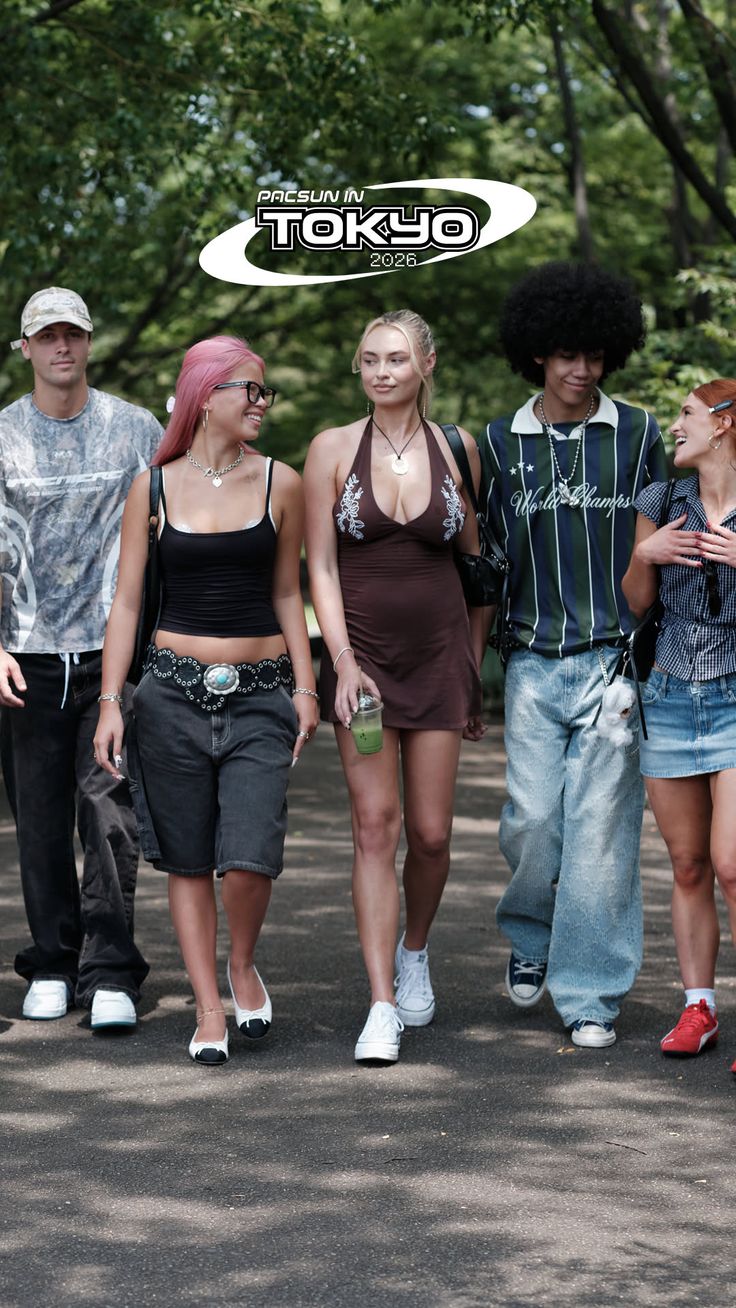 Group of young people walking outdoors, one woman in a halter dress with cleavage
