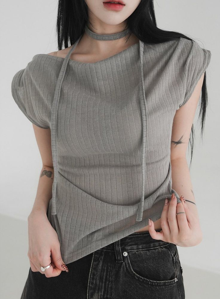 Woman with long black hair wearing a ribbed top and choker