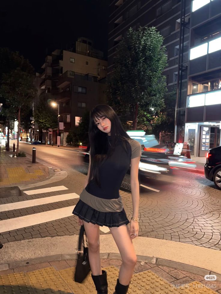 Woman with long hair in a mini skirt on a city street at night