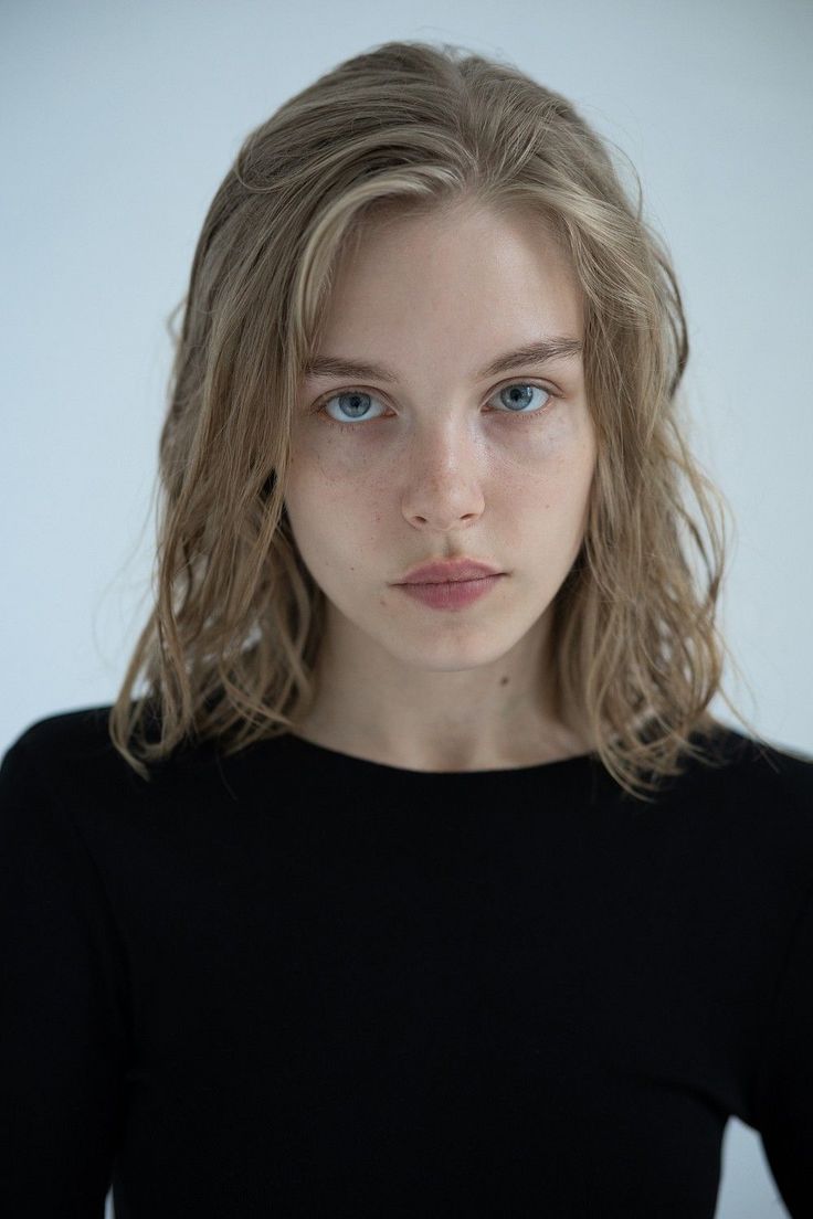 Woman with blonde hair and blue eyes wearing a black shirt
