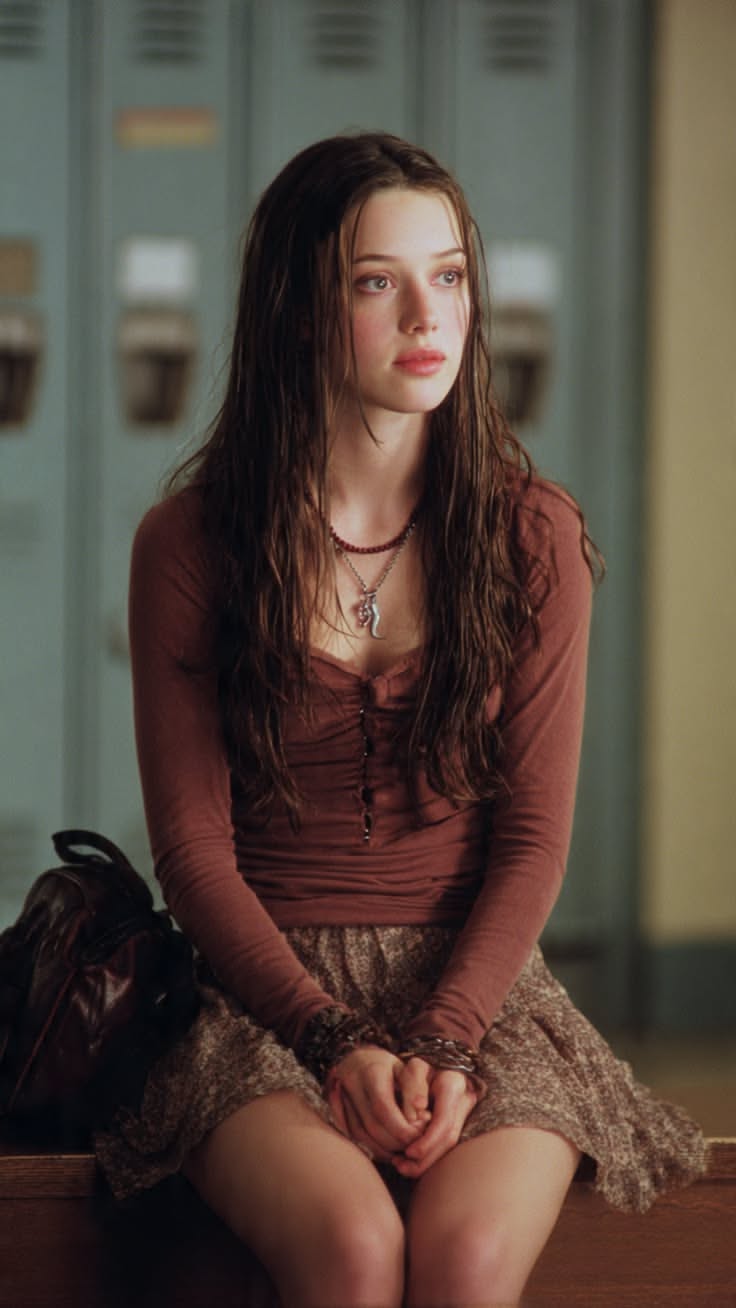 Young woman with long brown hair wearing a brown top and mini skirt indoors