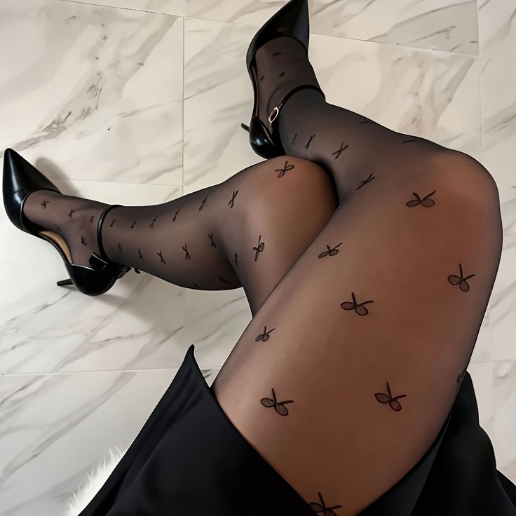 Person wearing black patterned tights and high heels on a marble floor