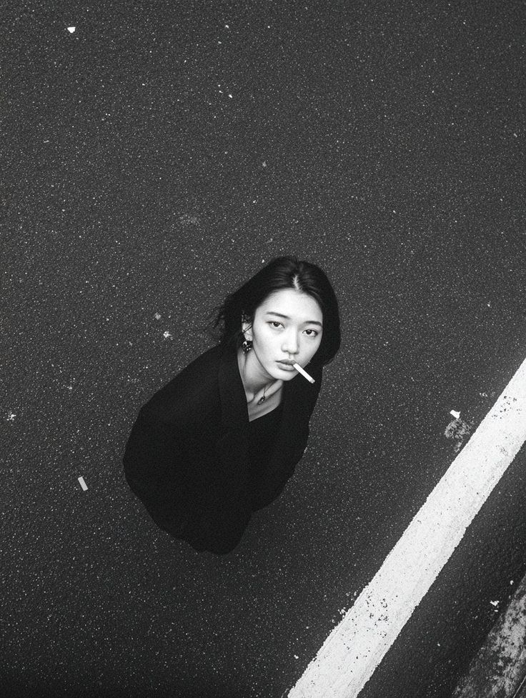 Woman with short hair smoking a cigarette on a street, shot from a high angle
