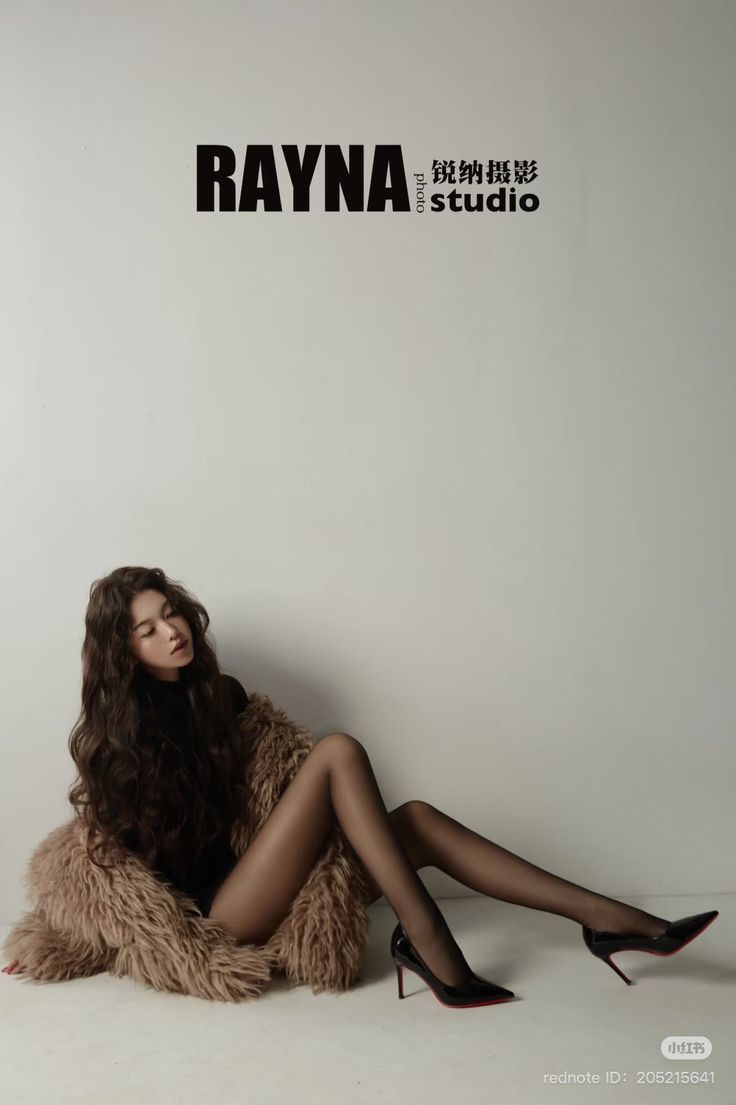 Woman with long wavy hair in black tights and high heels on a fur coat