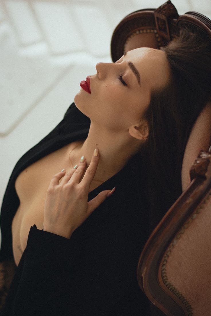 Woman with red lipstick and black jacket in a provocative pose