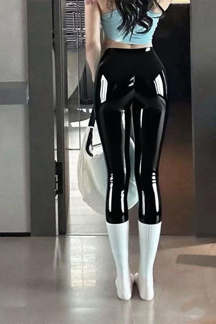 Woman in shiny black leggings and a crop top from behind