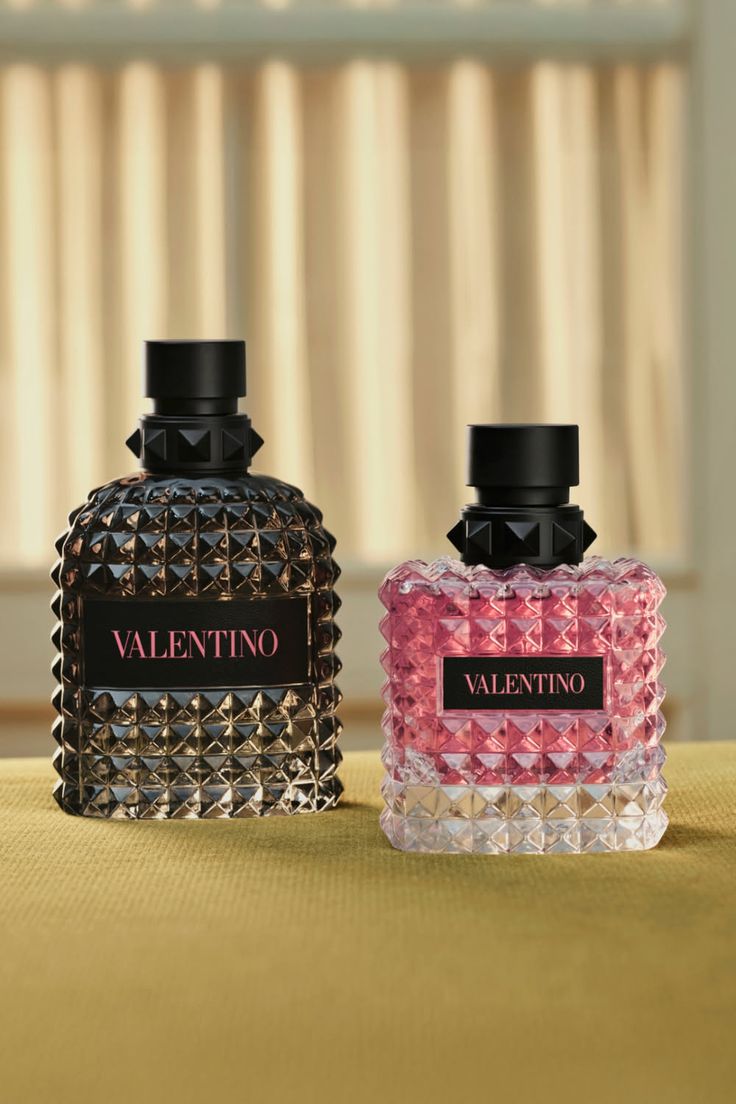 Two Valentino perfume bottles with studded designs, one black and one pink