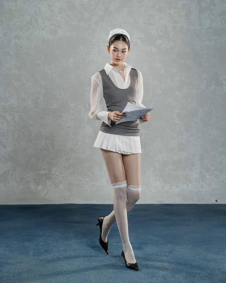 Woman in a white blouse, mini skirt, and thigh high stockings holding a paper