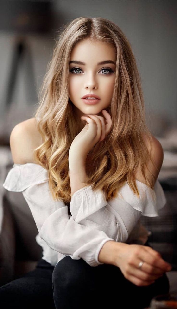 Woman with blonde hair and blue eyes wearing an off-shoulder top