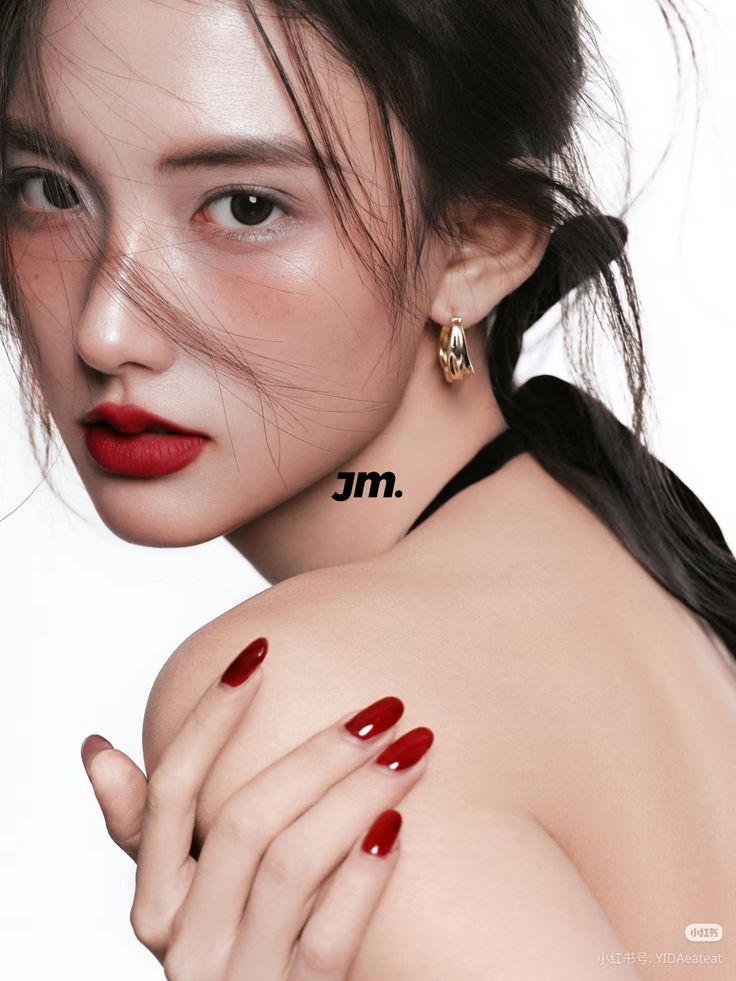Woman with red lipstick and nails, looking over her shoulder