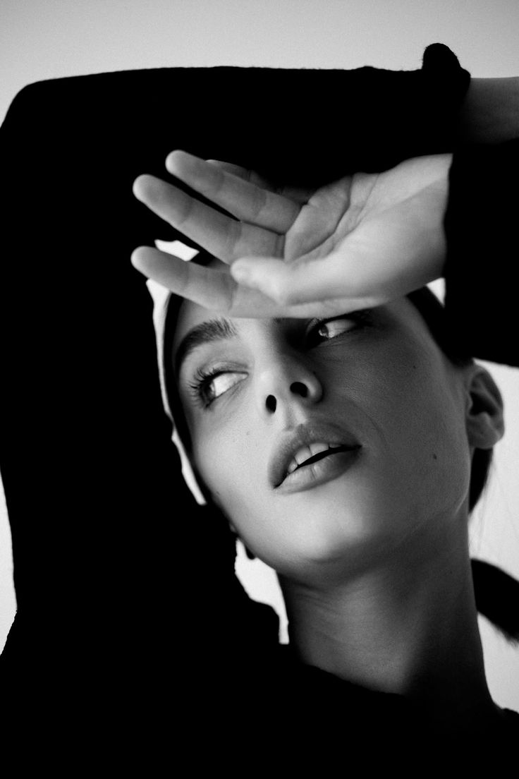 Black and white portrait of a woman with her hand shielding her eyes