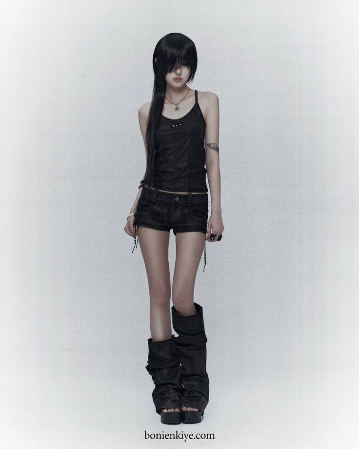Person with long black hair wearing a black tank top and shorts on a white background