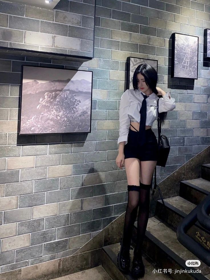 Woman in a cropped shirt and short shorts with thigh-high socks indoors