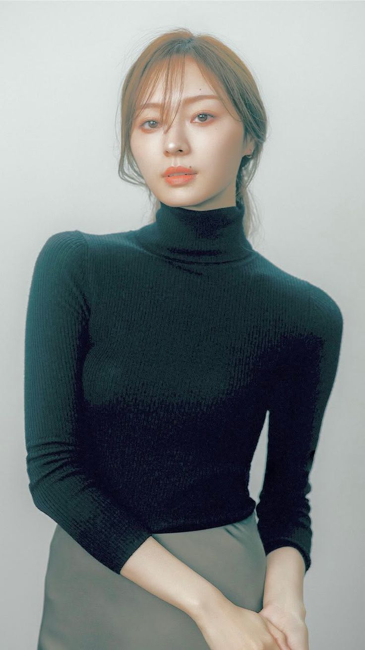 Woman in a black turtleneck with long hair and natural makeup