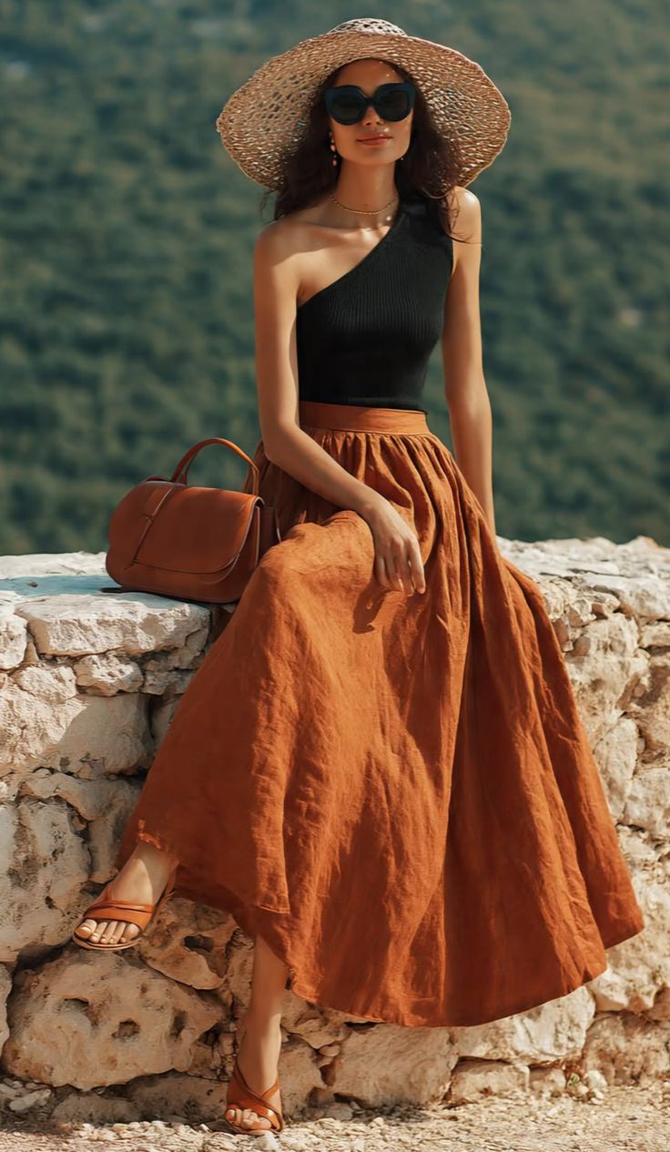 Woman in a straw hat and sunglasses sitting outdoors with a brown bag