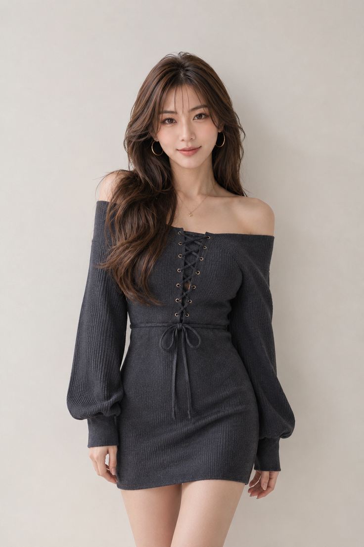 Woman in a dark grey off-shoulder dress with lace-up detail posing indoors
