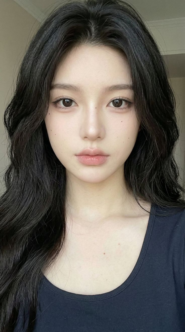 Woman with long black hair and dark eyes in a black top