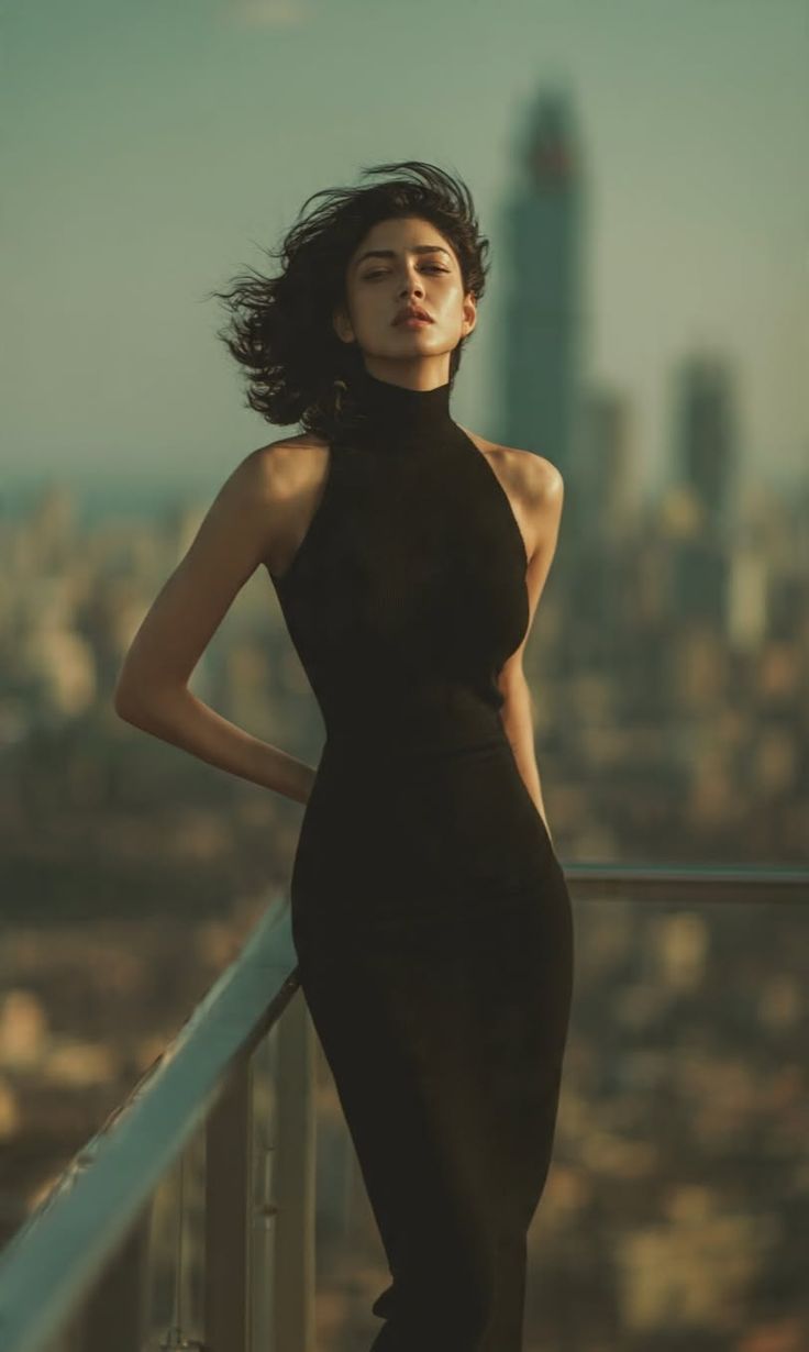 Woman in a black dress on a rooftop with a cityscape background