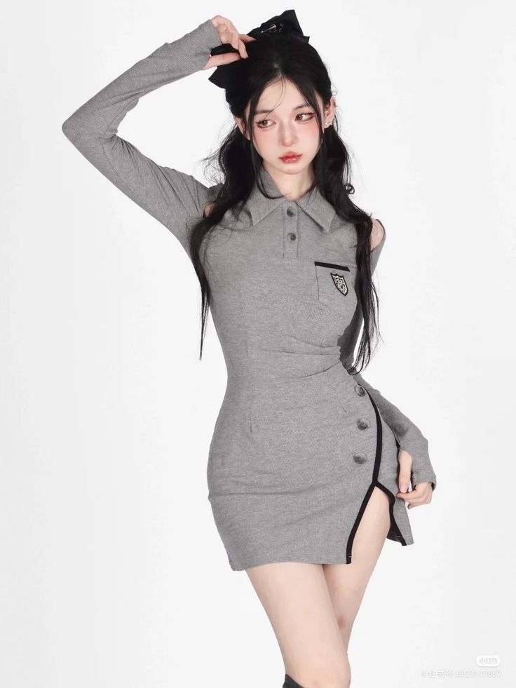 Woman with long black hair in a gray dress with a high slit