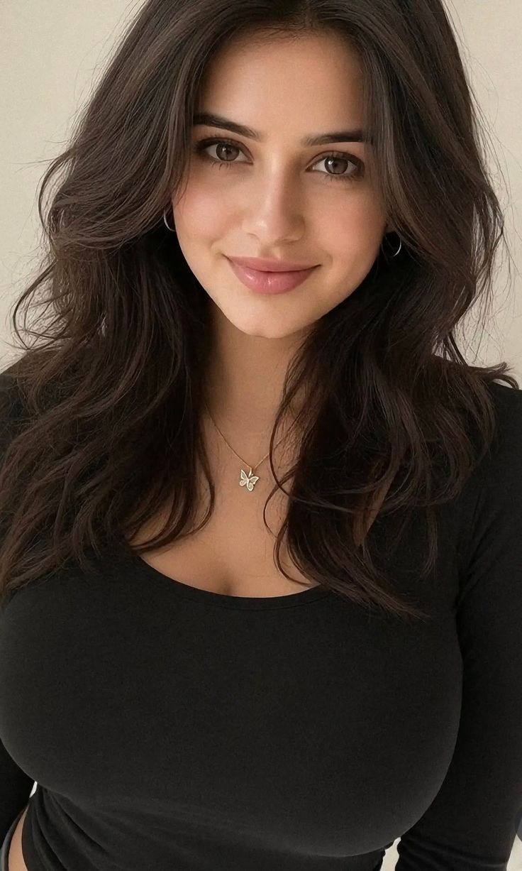 Woman with long dark hair and a butterfly necklace wearing a black shirt