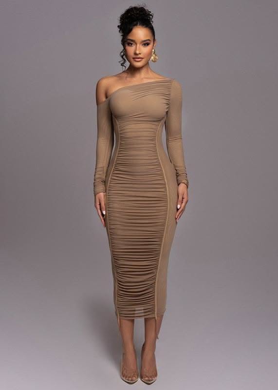 Woman in a ruched off-shoulder bodycon dress with an updo and gold earrings