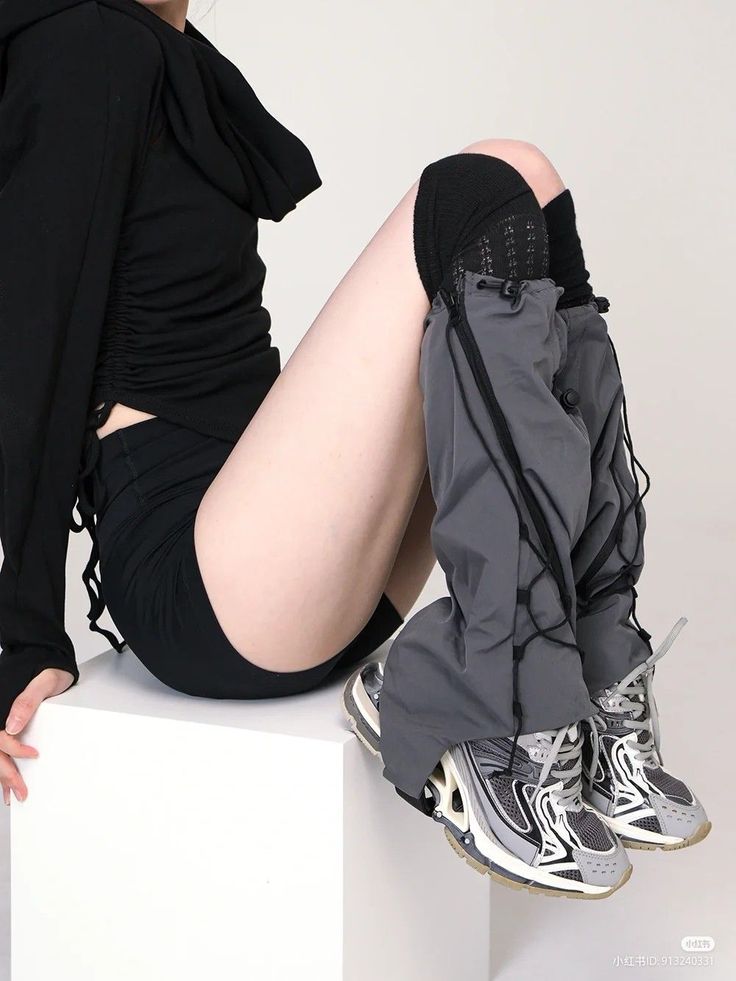 Person in a black hoodie and shorts with gray pants and sneakers
