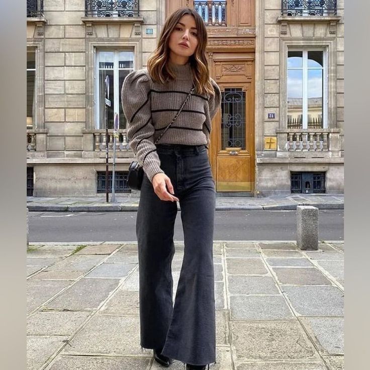 Woman in a striped sweater and flared jeans on a city street