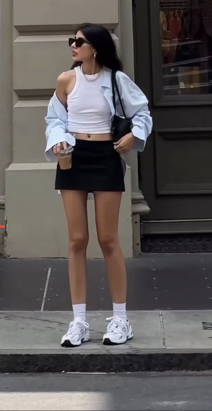 Woman in a black mini skirt and white crop top on a street