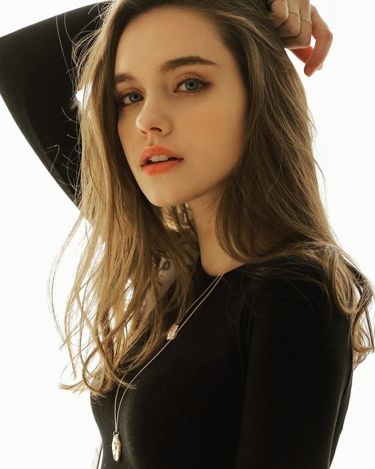 Woman with long hair and a black shirt, wearing a necklace
