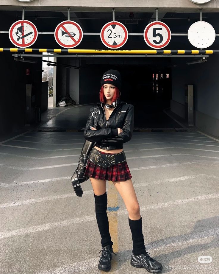Woman with red hair in a leather jacket and plaid skirt in an urban setting