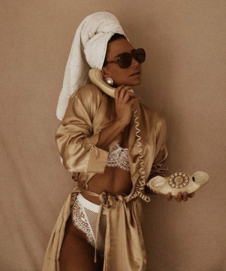 Woman in a satin robe and lace lingerie with a towel on her head and sunglasses