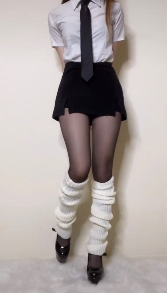 Person in a school uniform with black tights and white leg warmers