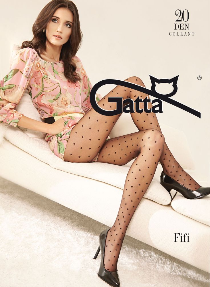 Woman with long hair wearing a floral top and heart pattern tights, sitting indoors