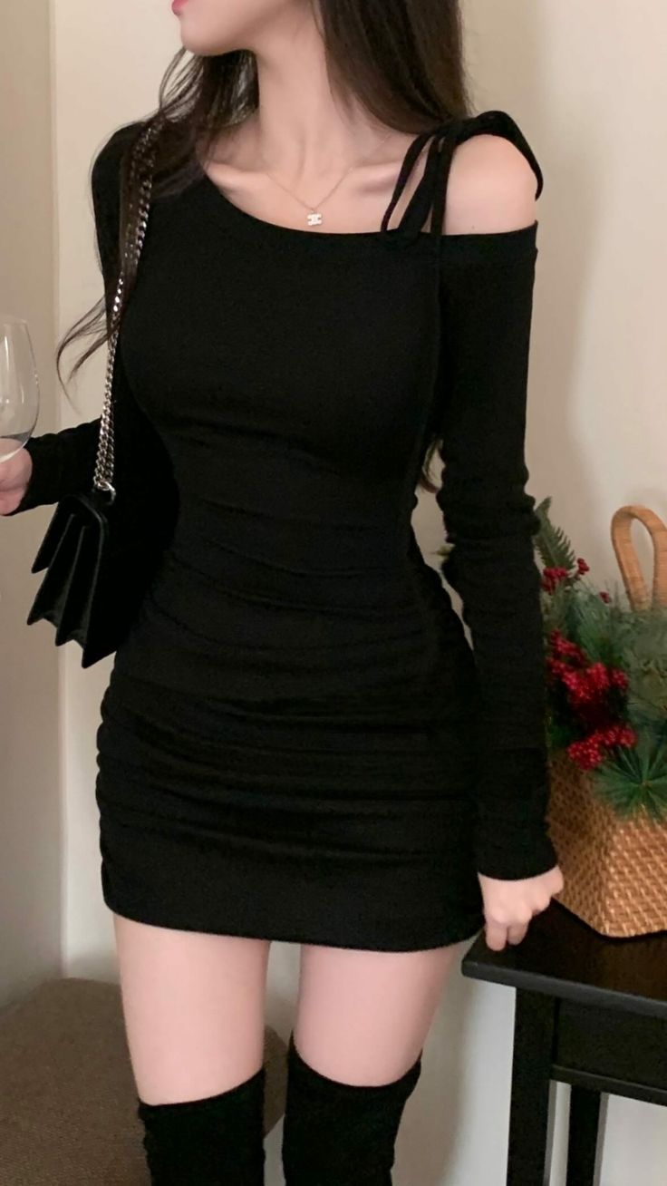 Woman in a black off-shoulder ruched dress and thigh-high boots