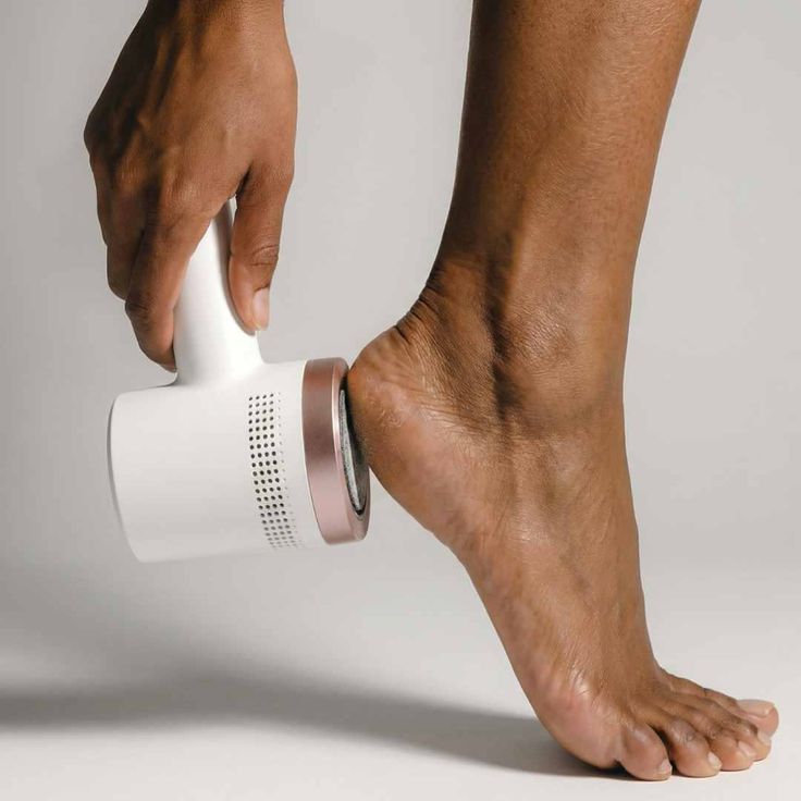 Hand using an electric callus remover on a foot