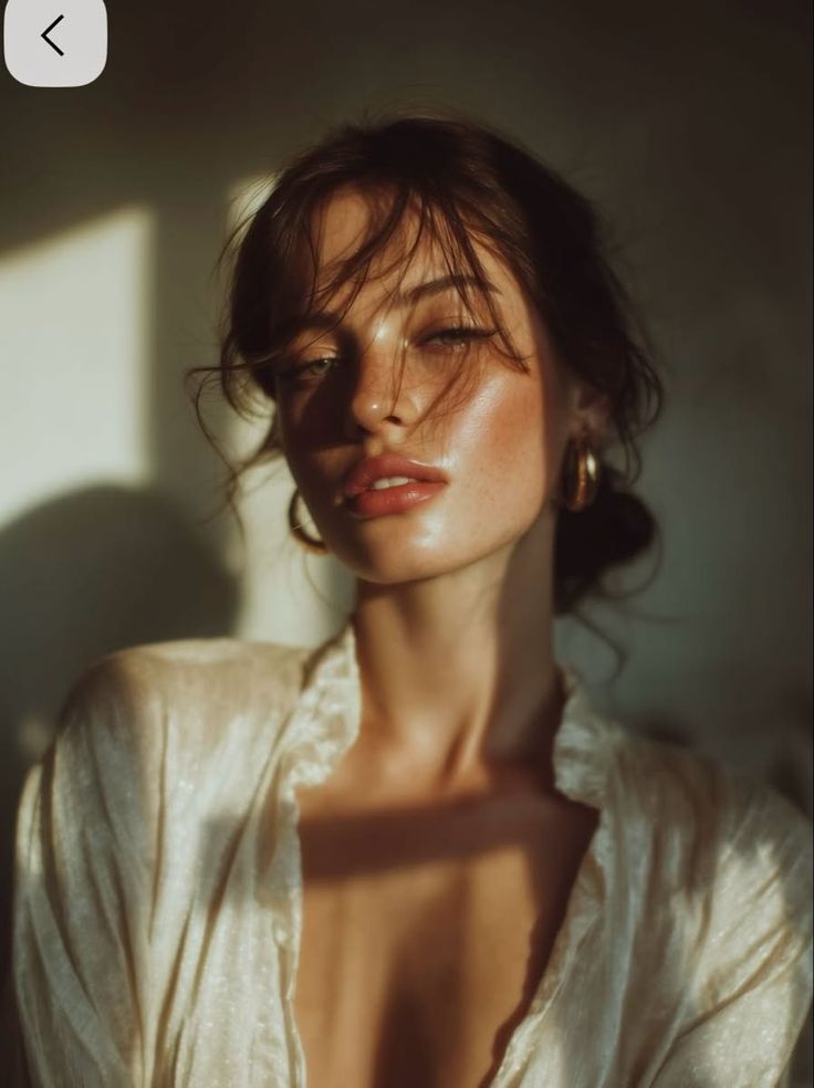Woman with messy hair and freckles in soft golden hour lighting