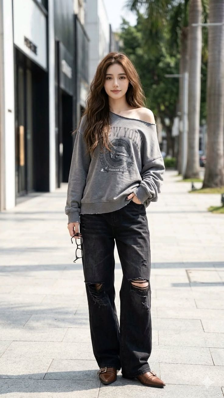 Woman with long hair wearing an off-shoulder top and ripped jeans on a street