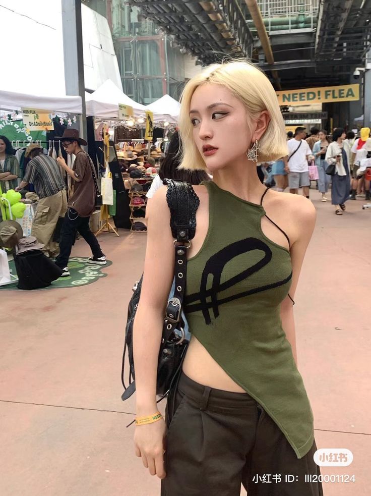 Woman with blonde short hair wearing an asymmetrical top at an outdoor market