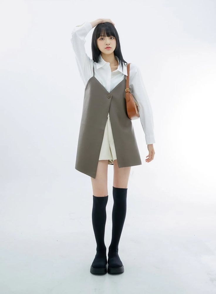 Woman with long black hair wearing a white shirt and sleeveless top with knee-high socks