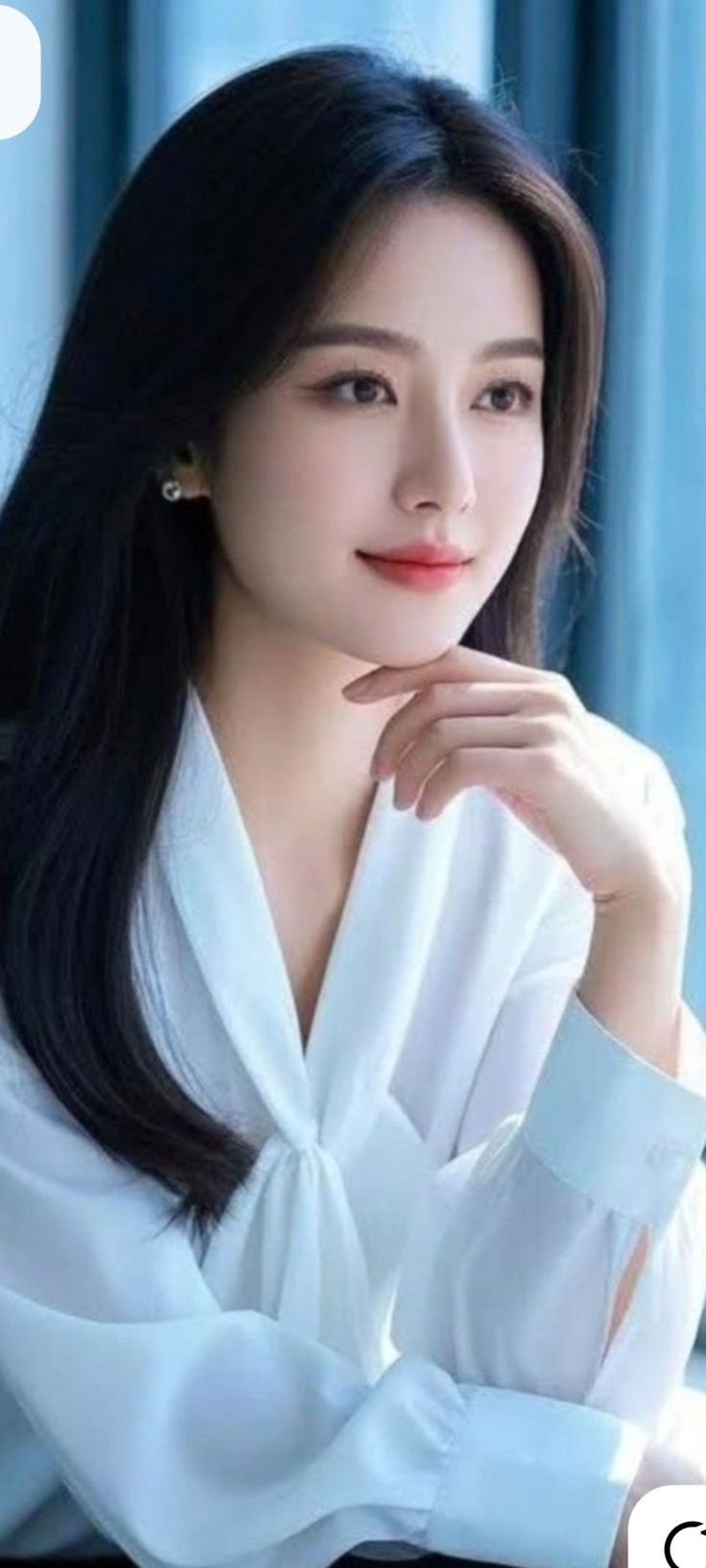 Woman with long dark hair wearing a white shirt, looking to the side
