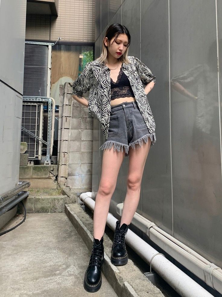 Woman in a zebra print shirt and denim shorts with a black lace bralette