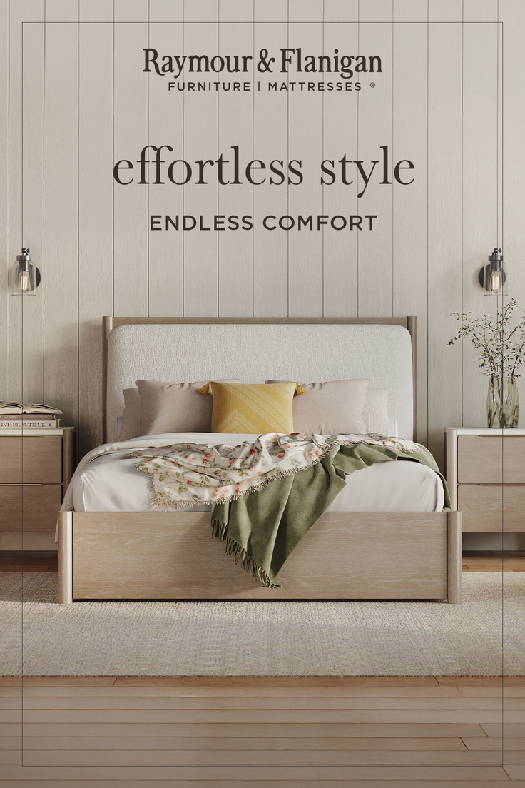 A cozy bedroom with a wooden bed frame, upholstered headboard, and neutral decor